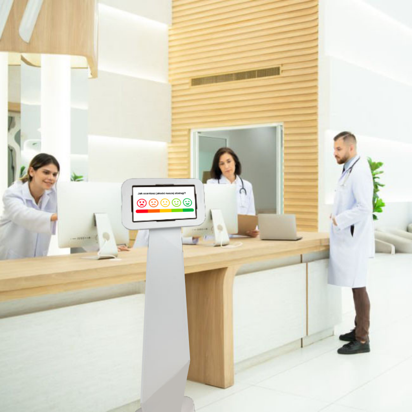 Kiosk do zbierania opinii pacjentów przy recepcji w przychodni.