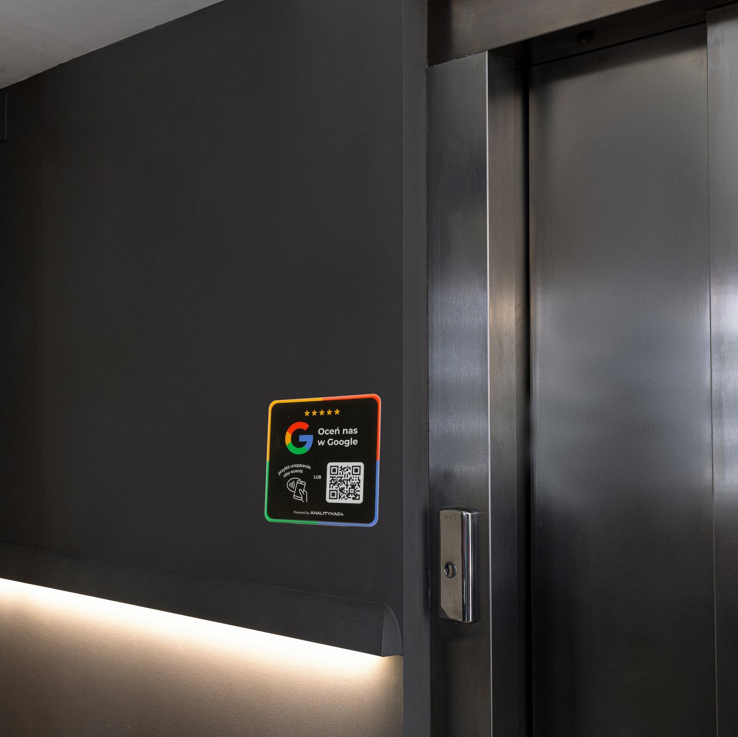 Czarna naklejka 3D QR/NFC przy windzie umożliwiająca klientom pozostawienie opinii